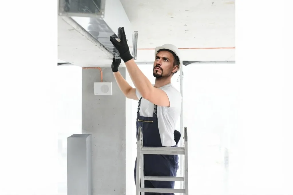 Technician checking airflow at an air conditioning vent
