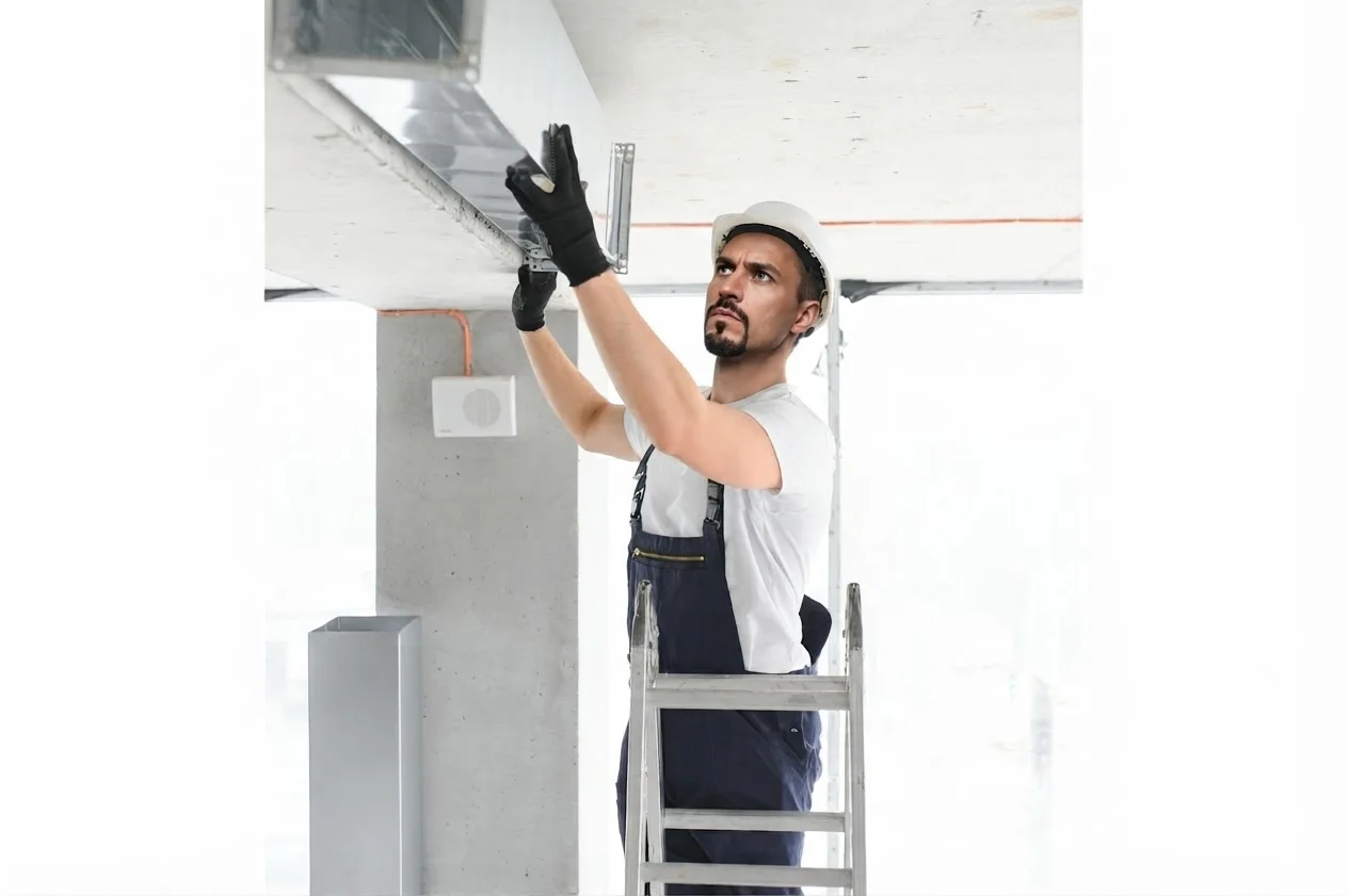 Technician checking airflow at an air conditioning vent