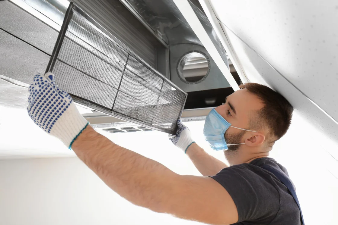 Technician cleaning an air filter to improve indoor air quality